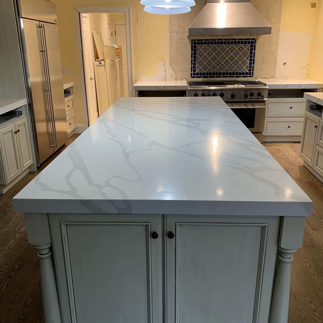 - 1 Marble kitchen island with elegant white surface and cabinetry. Perfect for modern kitchen design an.