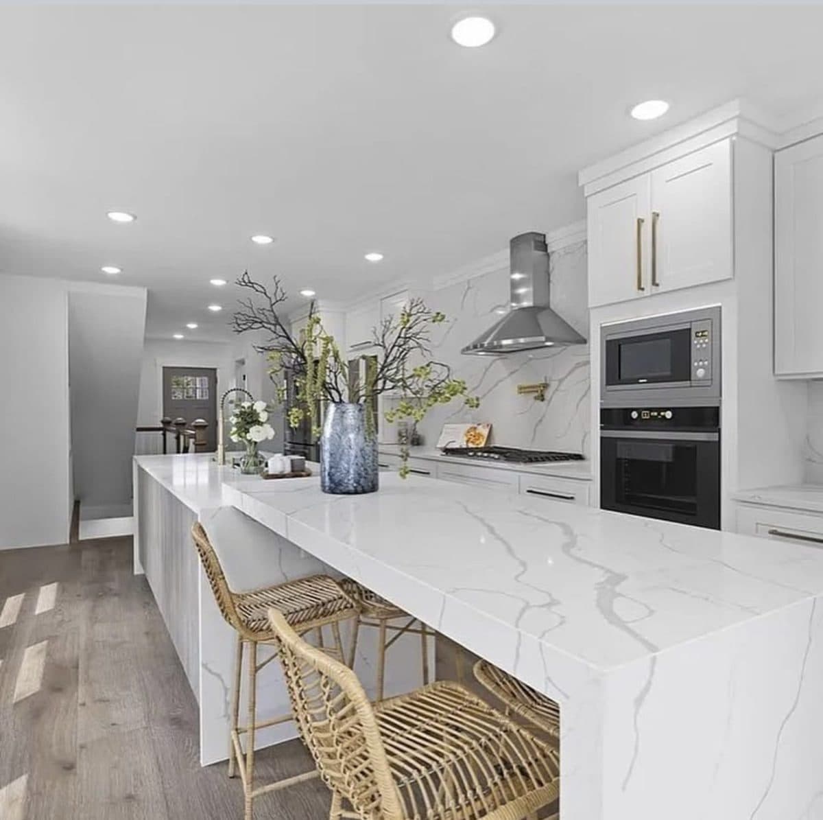 - 1 White kitchen with quartz waterfall island and marble backsplash in Waltham MA by Pablo Marble and Granite