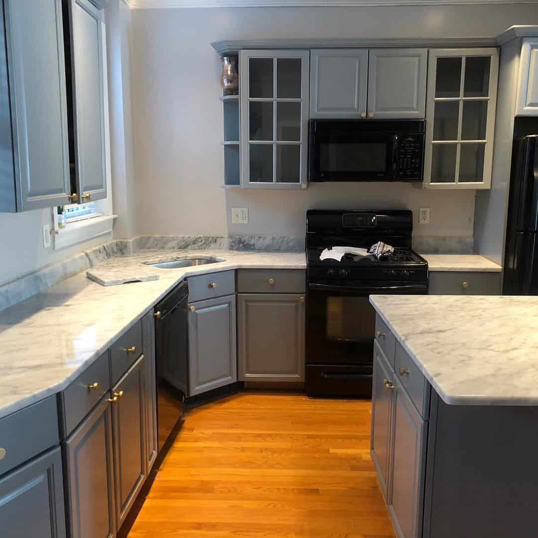 - 3 Marble kitchen countertops with grey cabinets and island after installation by Pablo Marble and Granite